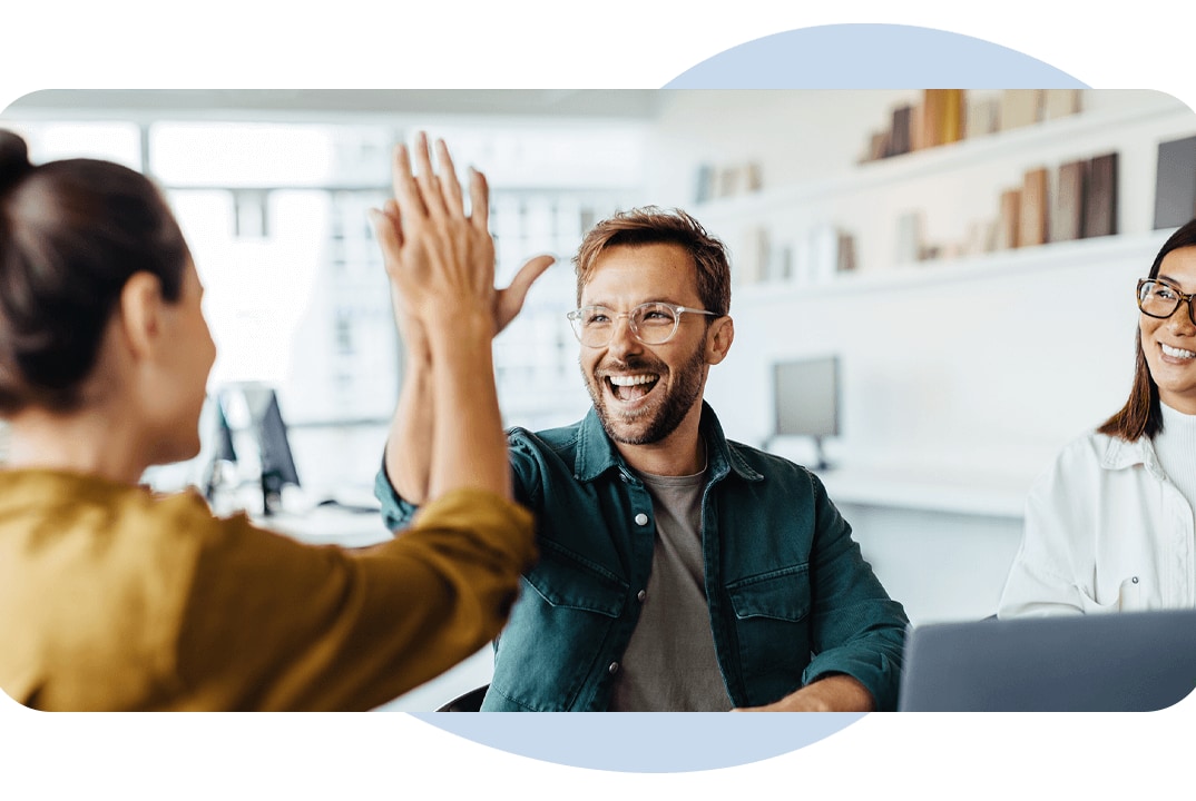 smiling people high five over laptop